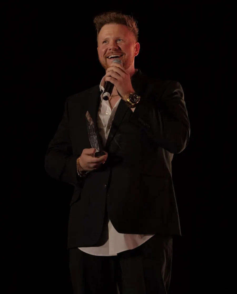 Blake Reynolds receiving an award on stage